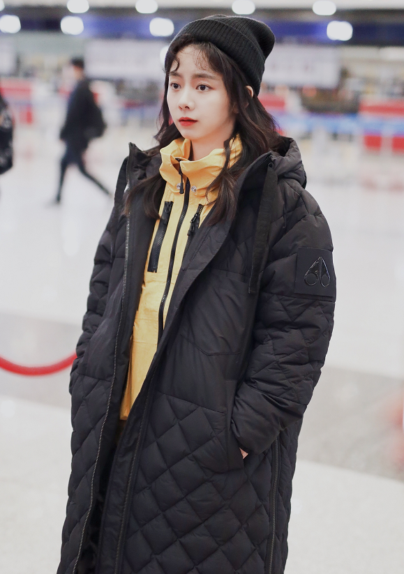 谭松韵身穿黑色宽大羽绒服表情呆萌羊毛卷发型非常甜美