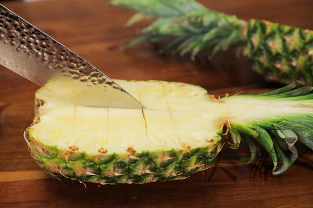 2.凤梨从中间切开,用刀划成方块,用勺子把菠萝肉挖出来.1.