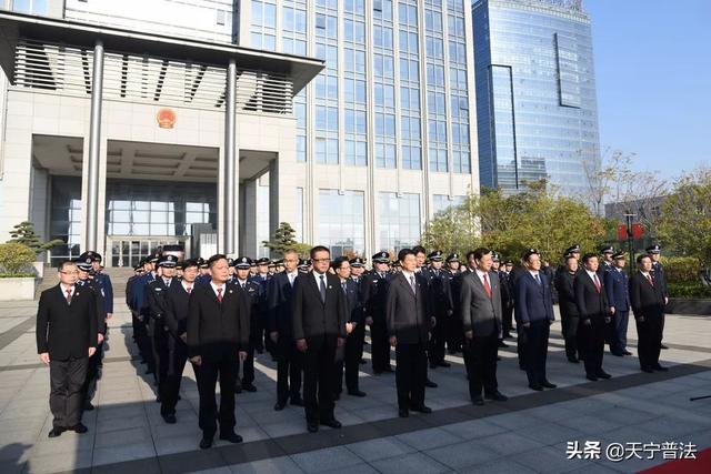 在副区长陈旭光的带领下,我区行政执法人员站在国旗面前,举起右拳进行
