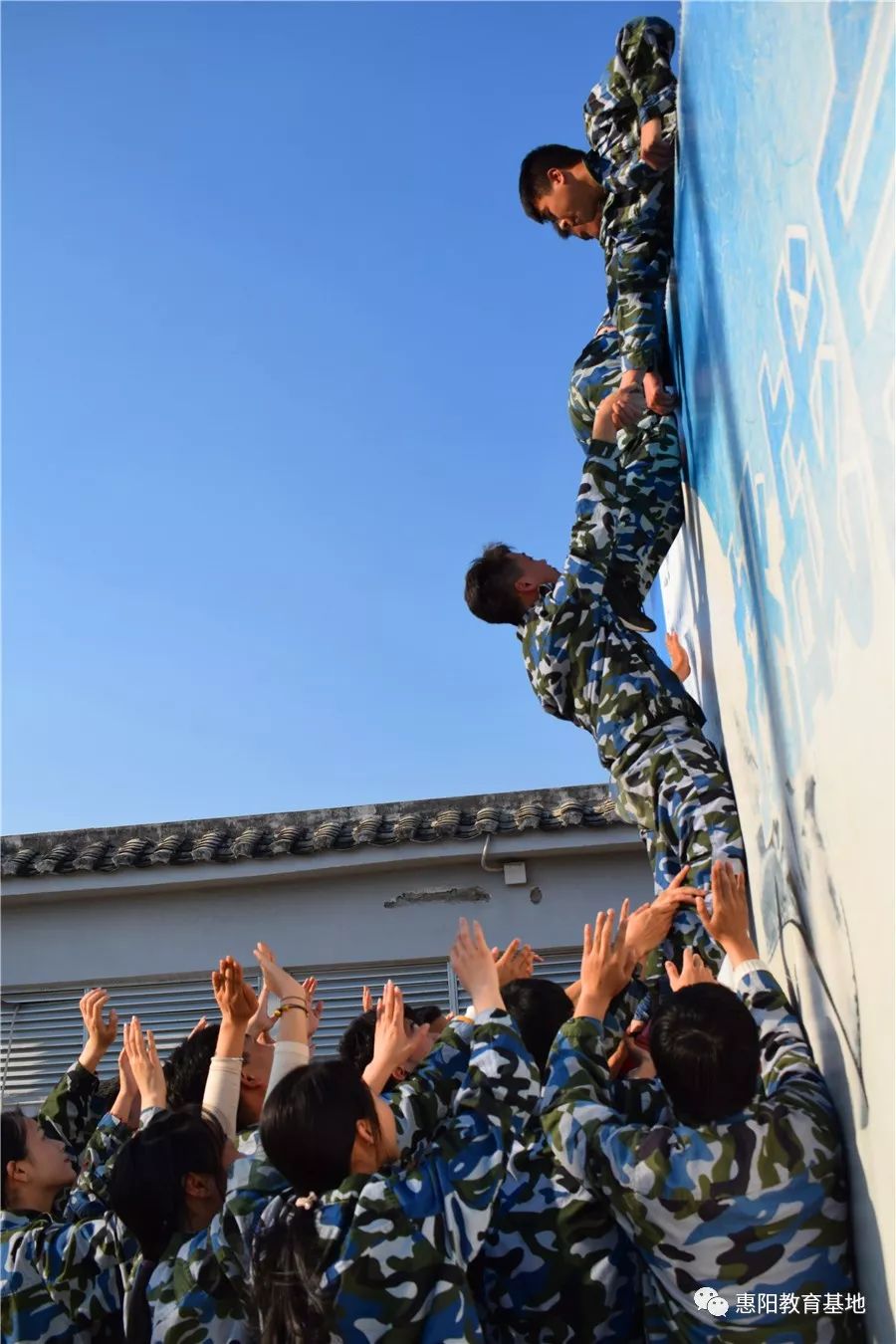 身体素质好的男生采用"叠罗汉"的方式搭成人梯,为其他成员的攀登奠定