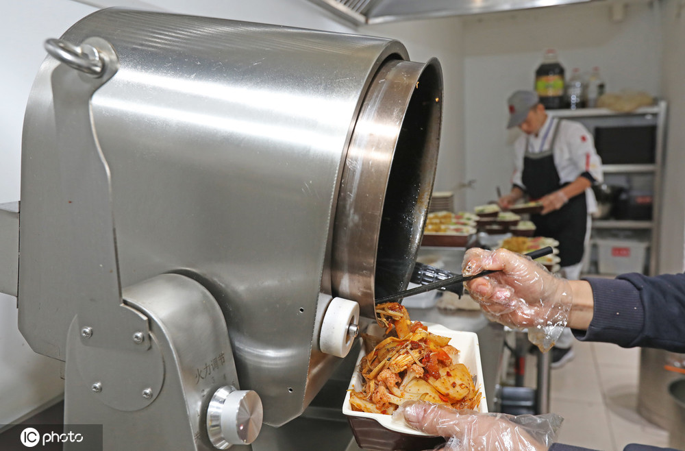 高校食堂现自动炒菜机器人 30秒一盘菜