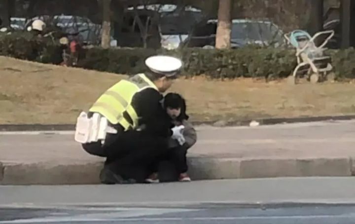 小女孩蹲坐路边 萧山交警用身体为她挡风_于耿琦