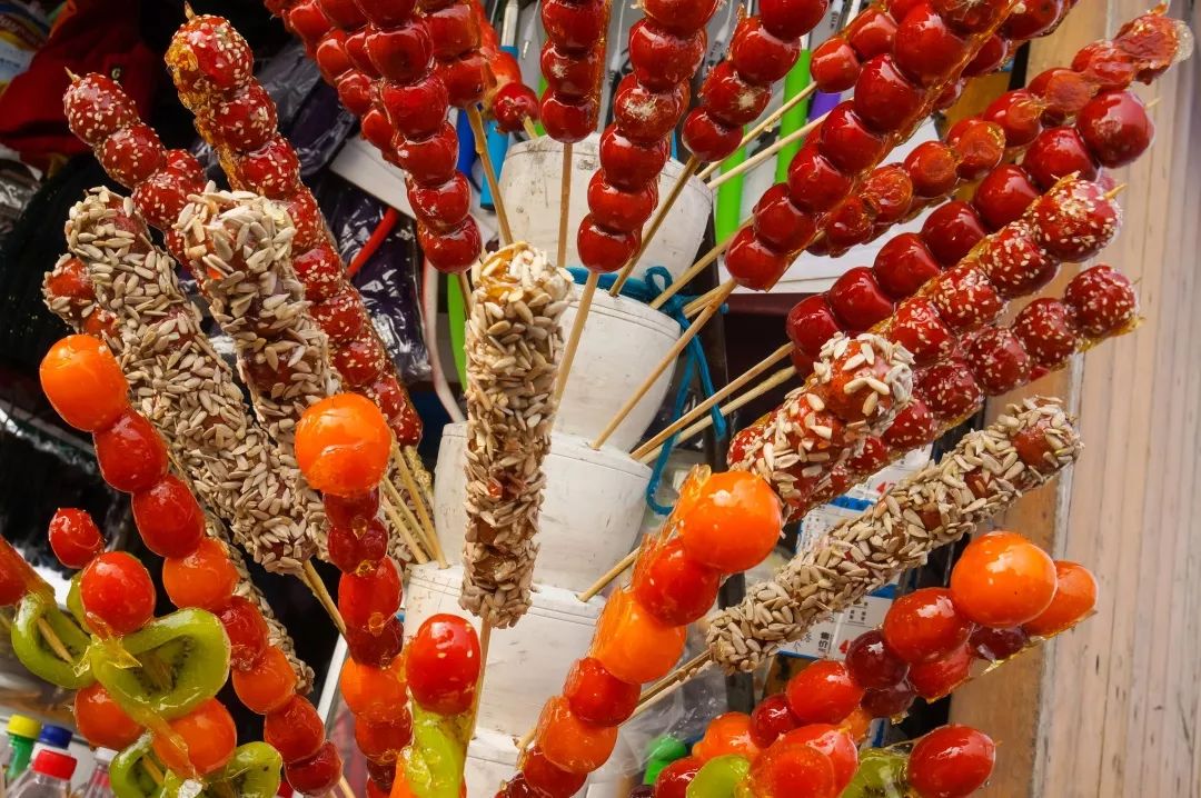 在厨师的帮助下,小小冰糖葫芦娃们让手里的糖葫芦均匀的沾上糖浆,给