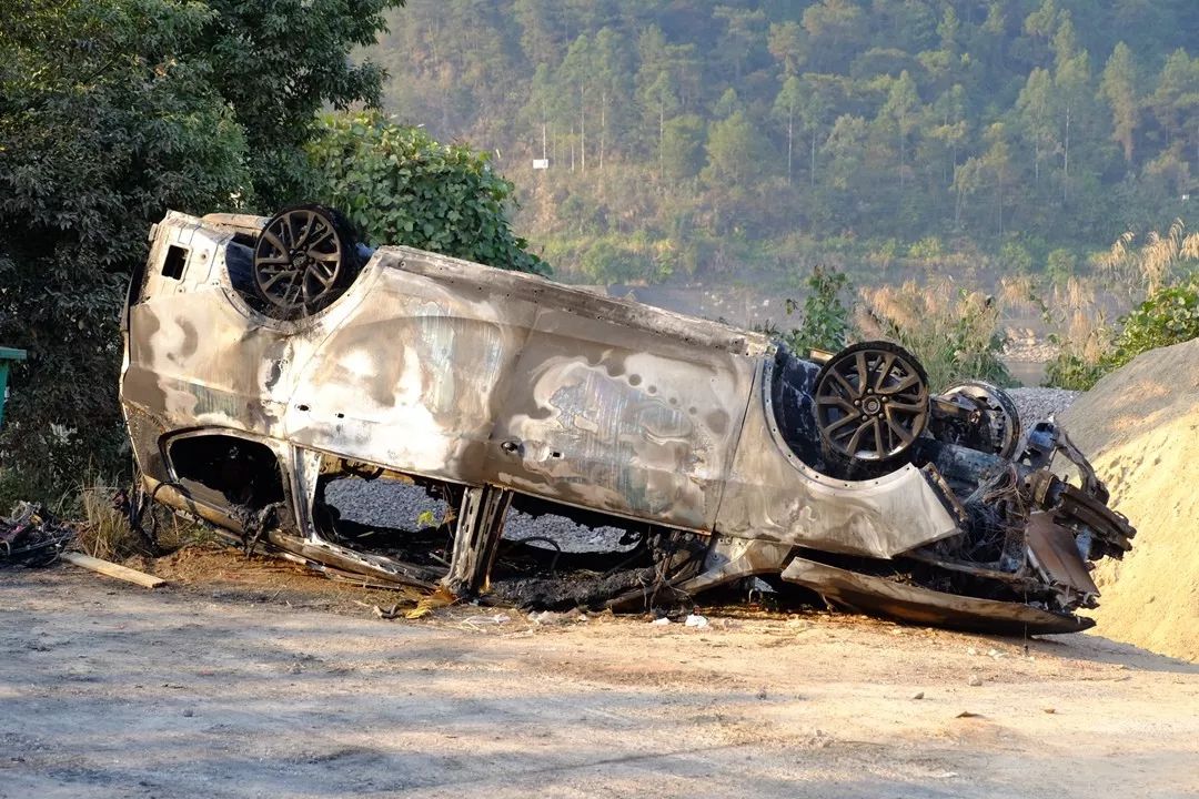 事故现场被烧毁的面包车早上六点四十左右,消防人员正在扑灭着火的