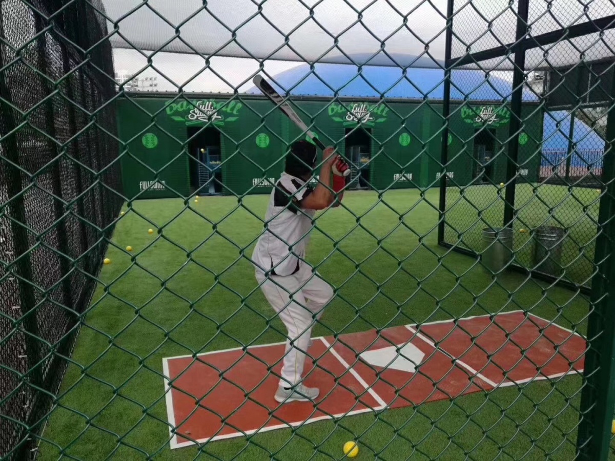 与传统棒球场地不同,户外棒球打击场外围有一圈球网,在球网场地中进行