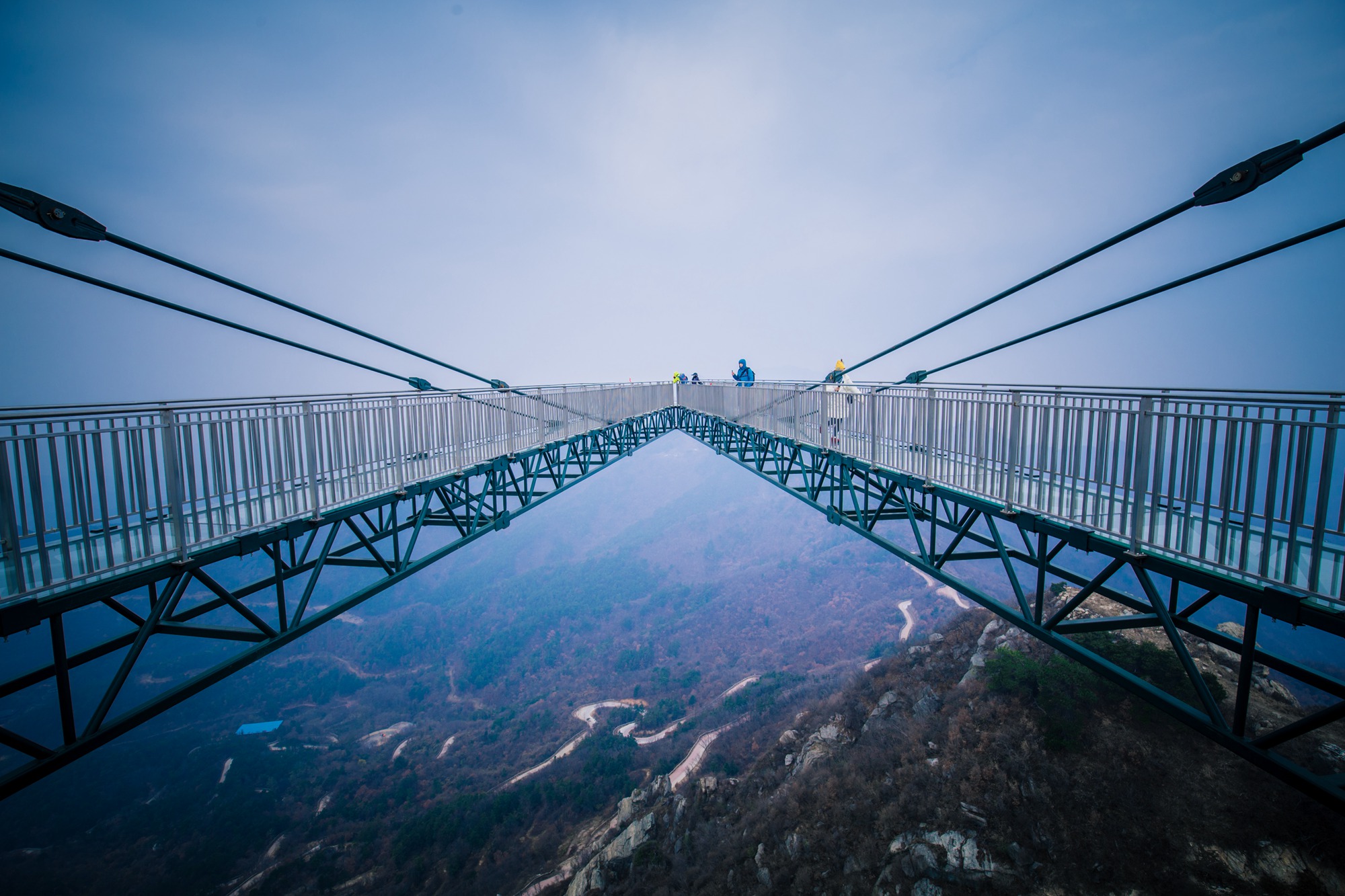 玻璃平台上寒风嗖嗖,需要穿上棉大衣保暖,走在玻璃栈道上晃晃悠悠的