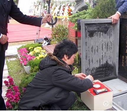 安放工人三鞠躬后负责对墓穴封穴施工,将附属狮子,香炉,花瓶固定好