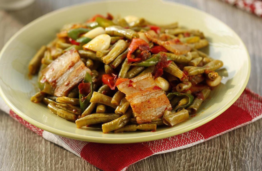 【酸豆角回锅肉】制作:锅中放入冷油和少许冰糖,炒至冰糖融化成棕红色