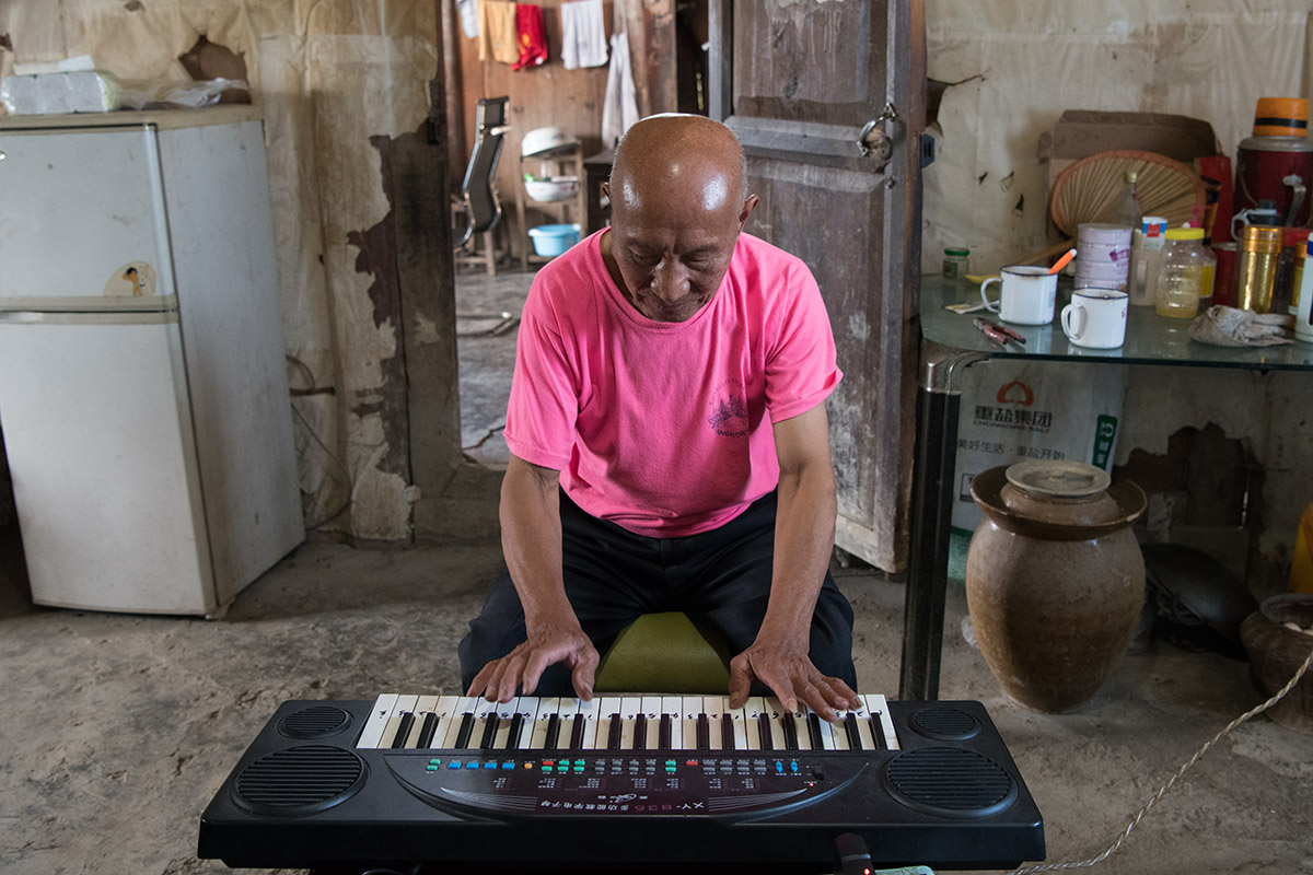 年轻时劁猪骟牛,退休后垫资修通村道,弹琴是爱好