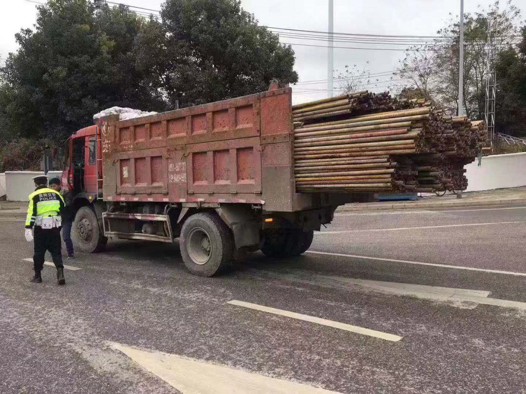这是辆轻型自卸货车,货厢有3米多长,运载的钢管超长,伸出货厢外1米