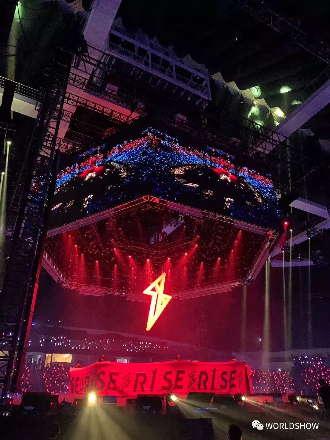 少年们从舞台中央升起,写有"r1se"的横幅将他们围成一圈,头顶的闪电