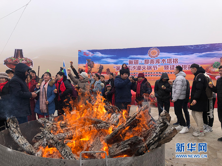 12月22日,游客们体验围着火炉吃西瓜.新华网 李梦婷 摄