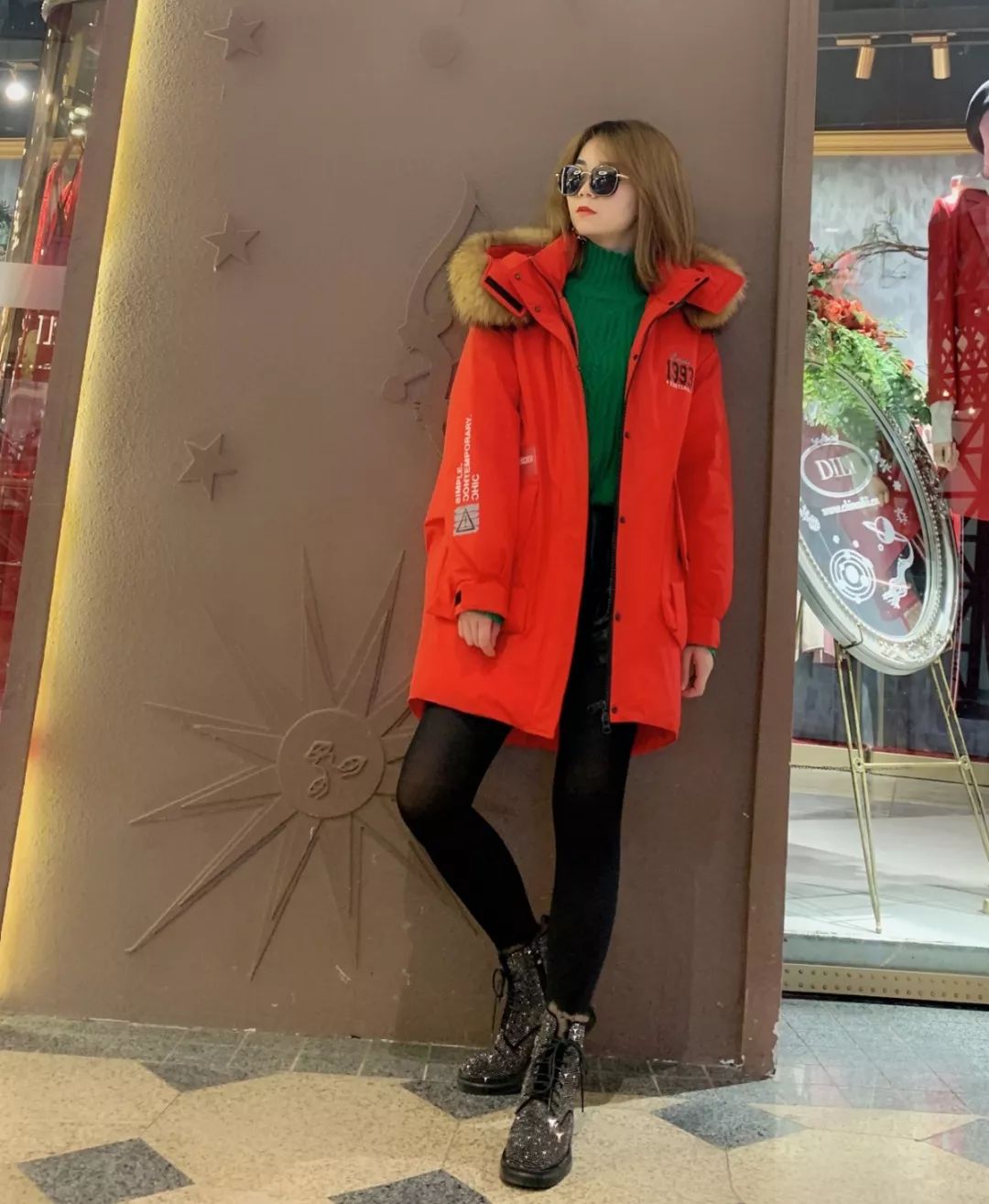 红色派克服里面配以绿色毛衣大面积红用一点绿色加以点缀整体颜色丰富