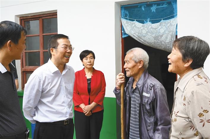 郭志英(左二)在和贫困群众交谈.