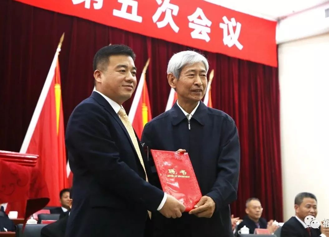 刚从华安县政府县长简洪坤手中接过县域经济社会发展专家顾问聘书后
