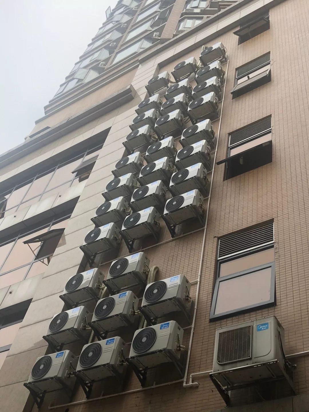 密密麻麻广东一大厦外墙挂着100多台空调外机街坊走过都怕