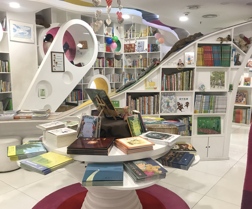 北京蒲蒲兰绘本馆,两个孩子在老师的指导下阅读绘本.