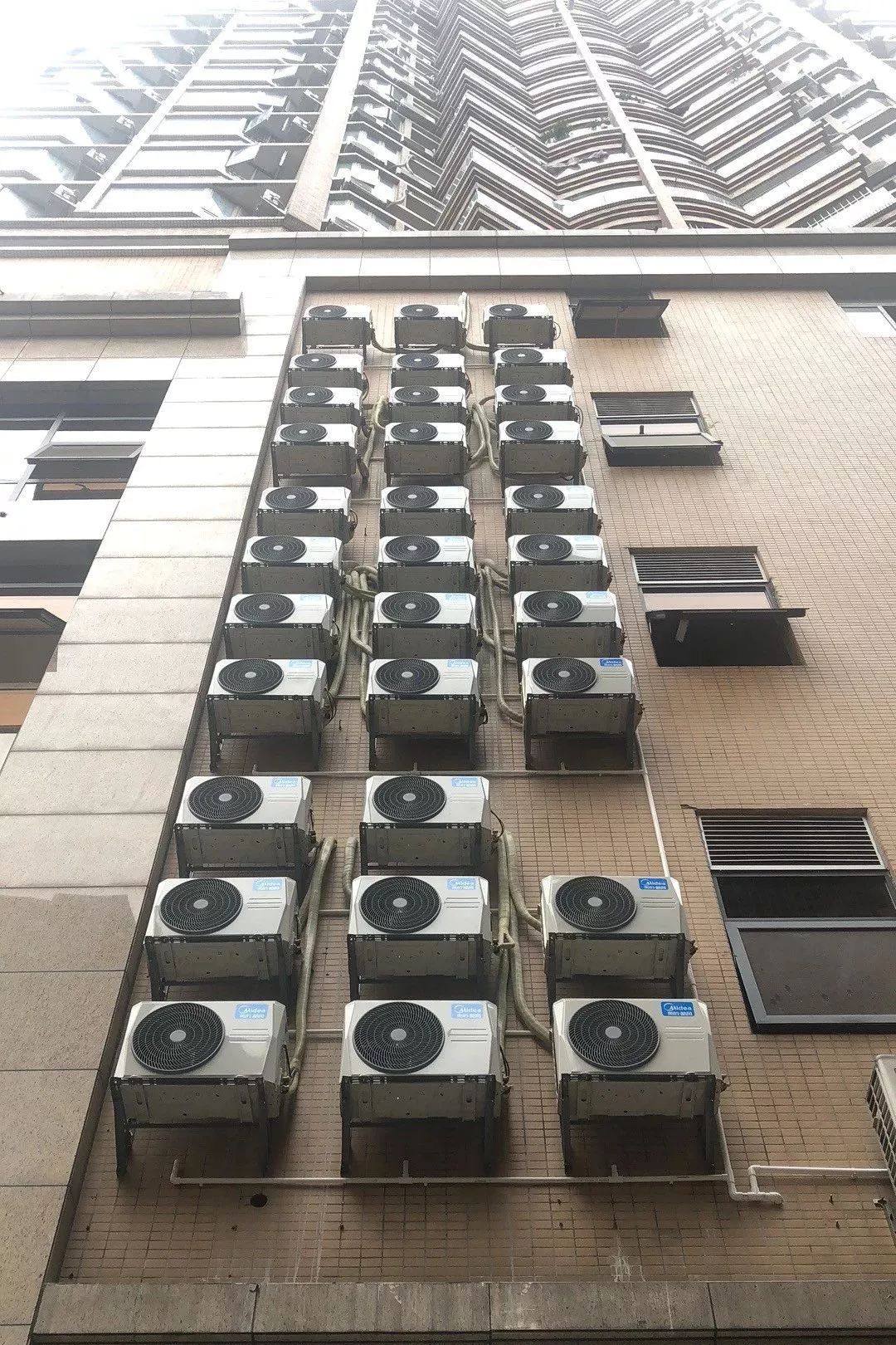 广东一大厦外墙挂着100多台空调外机!街坊:走过都怕!