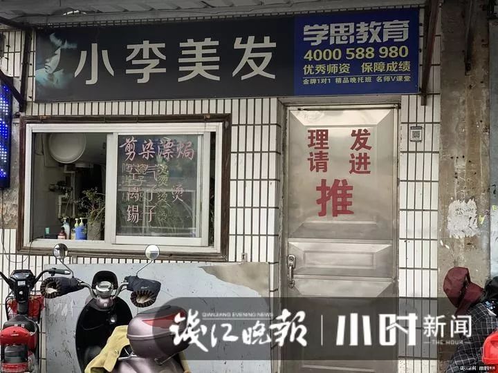 店面左边是发廊常见的霓虹灯,右边一扇铁门上贴着简单的"理发 请进 推