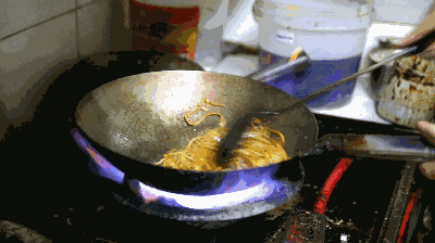 颠勺儿表演火焰沿着锅底攀爬到锅上方好像连带着面条开出一蓬火花等