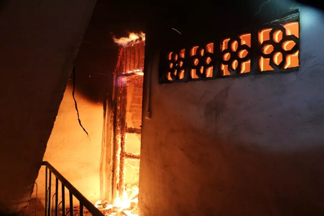 一民房四楼冒出了滚滚的黑烟,不时就有火苗窜出来.