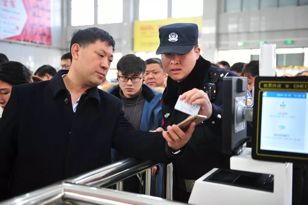 金寨火车站派出所民警吕锦鹏(前右)在检票口执勤(12月19日摄.