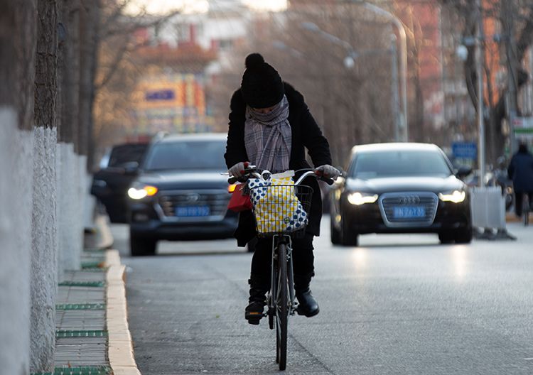 海淀区文慧园路,市民顶风骑行.