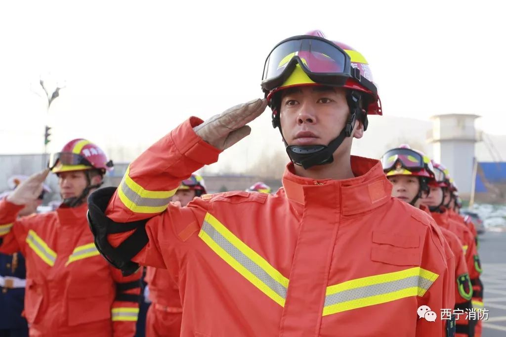 护送中国消防救援队队旗从队伍前走过,全体指战员向队旗庄严敬礼
