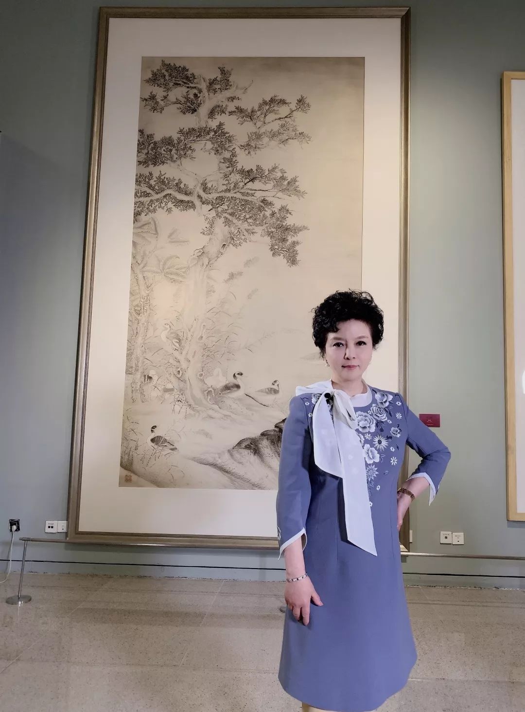 主持人丛薇在徐里书记画作前《中国近现代美术经典丛书——徐悲鸿》卷