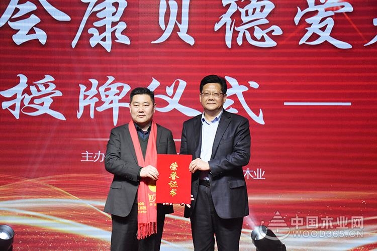 年会现场,山东峰泰康贝德木业董事长郑宪富登台向临沂慈善总会捐款100