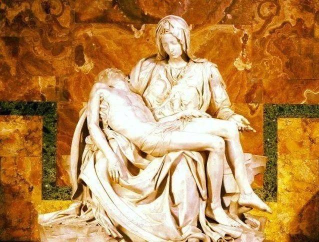 这是一座润泽的白玉石雕像;慈爱的圣母玛利亚垂着眼帘,怀抱着她的孩子