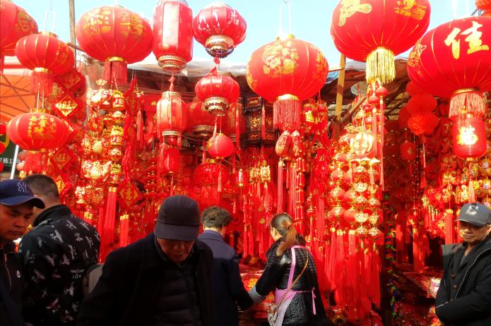 图为贵钢花鸟市场集市上年货销售铺位,大红灯笼高挂,尽显喜庆祥和.