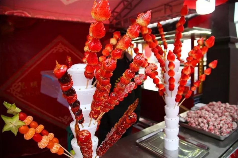 糖稀包裹着山楂或者草莓离开了热锅老北京冰糖葫芦在深冬的冷空气中