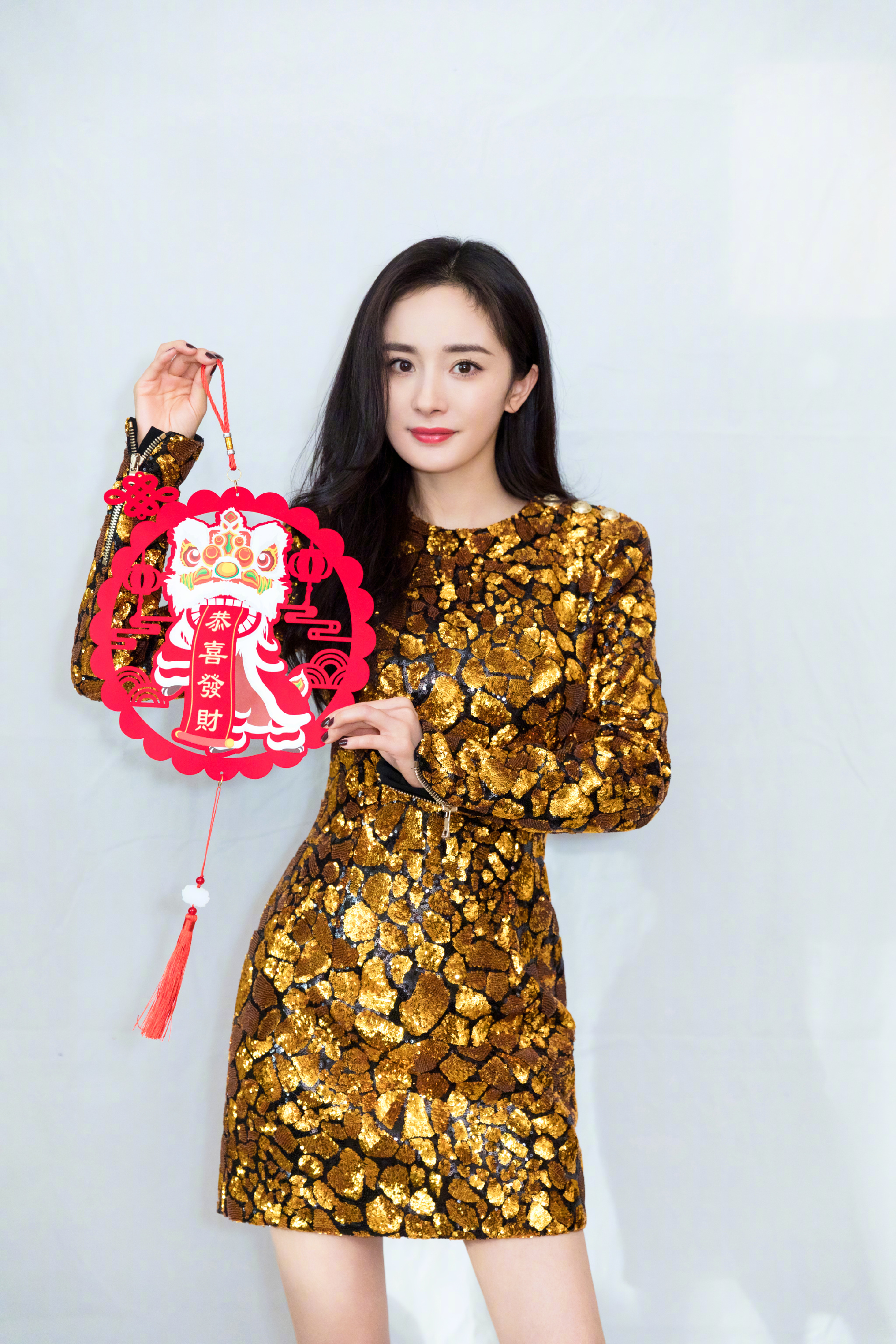 这次拍摄的新年写真,杨幂身穿了一条金色亮片包臀礼服裙,其中金色颜色
