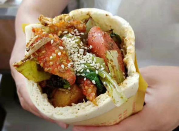 这种新流行的街头小吃叫做布袋馍,也叫口袋馍.