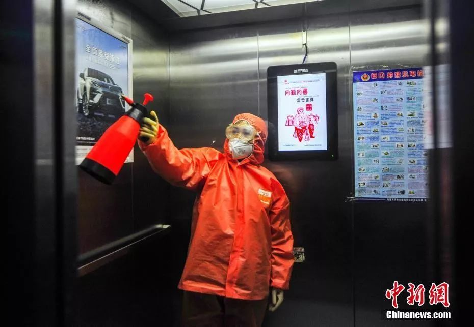 新疆乌鲁木齐市南昌路社区工作人员为辖区一公共电梯间进行消毒