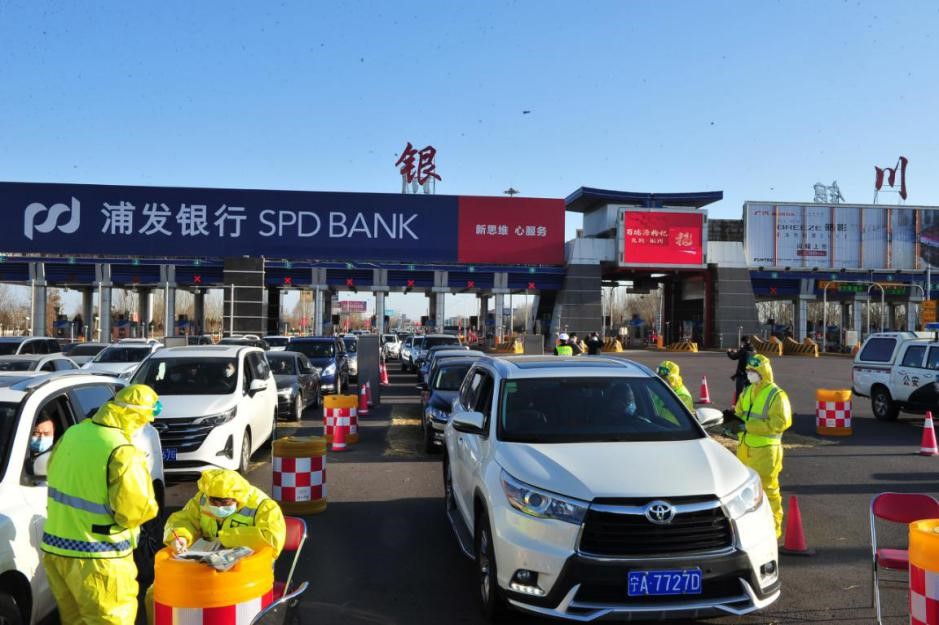 2月2日16时30分,青银高速银川东收费站,工作人员对来宁车辆及人员进行