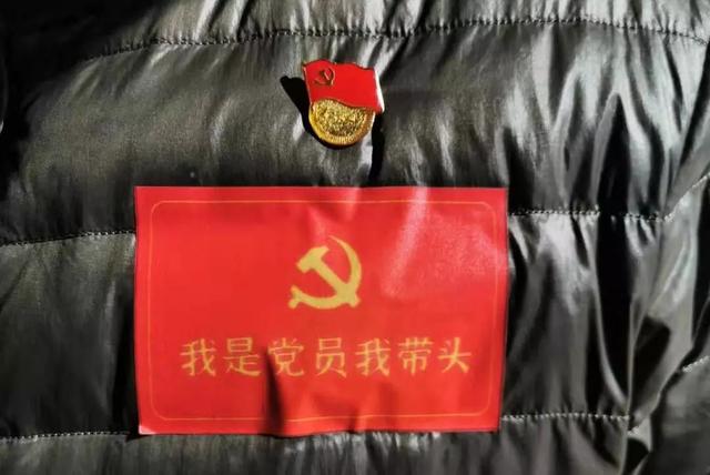 党员我带头"的红色标志和左臂上的"胶州市疫情防控志愿者"红色袖标在