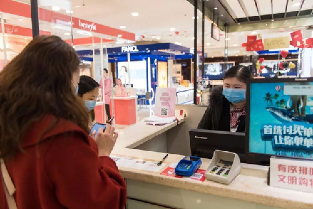 (2月10日,在长沙王府井百货商场,消费者在收银台买单.
