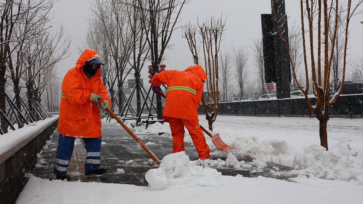 北京迎降雪环卫工人清理积雪