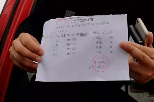 卡口处,许海军向工作人员出示人员不发热证明.