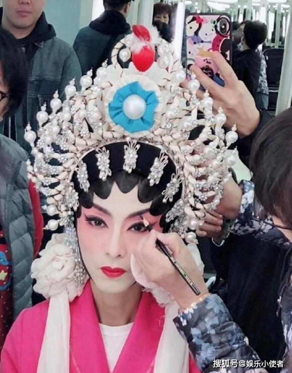米雪戴白色头饰,一副京剧演员的扮相,吊眉,挺鼻,浓烈的
