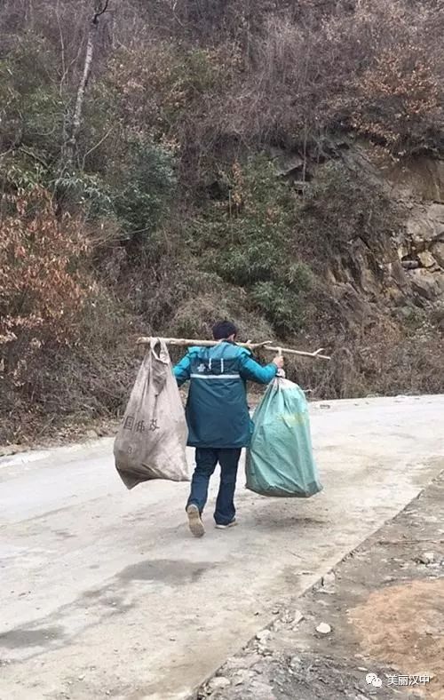 这是路人拍下的汉中邮递员挑担子走山路送包裹的照片近日,汉中一位挑