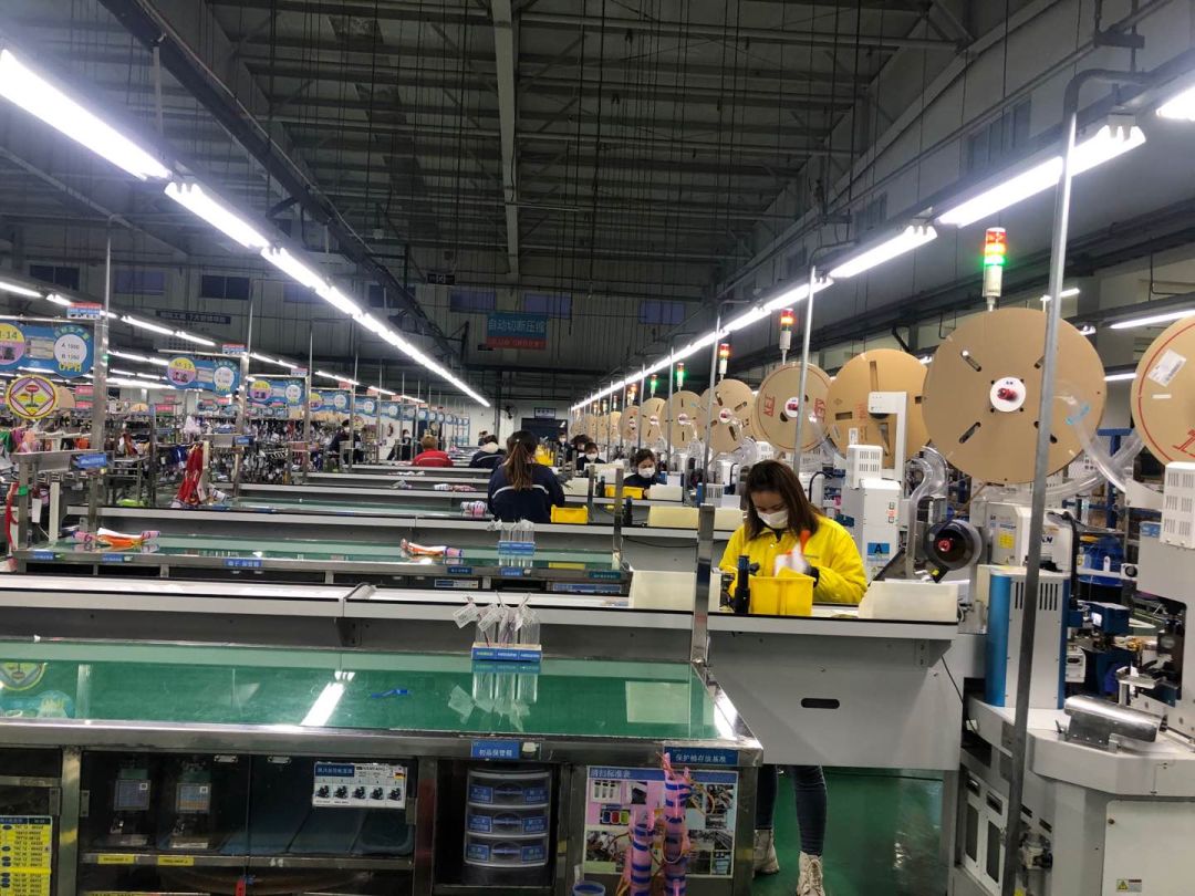 电子有限公司员工逐一进行消毒及体温测量,工人们进入车间开始一天的