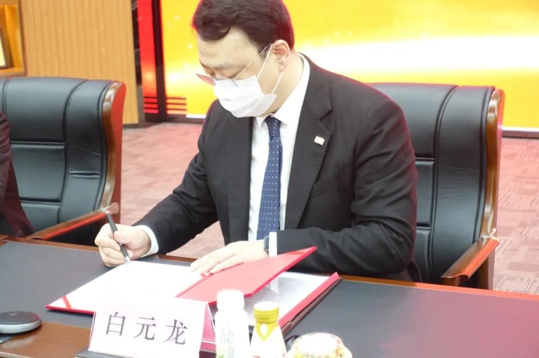 下,江宁开发区管委会副主任俞旭东与卫岗集团董事长白元龙戴着口罩