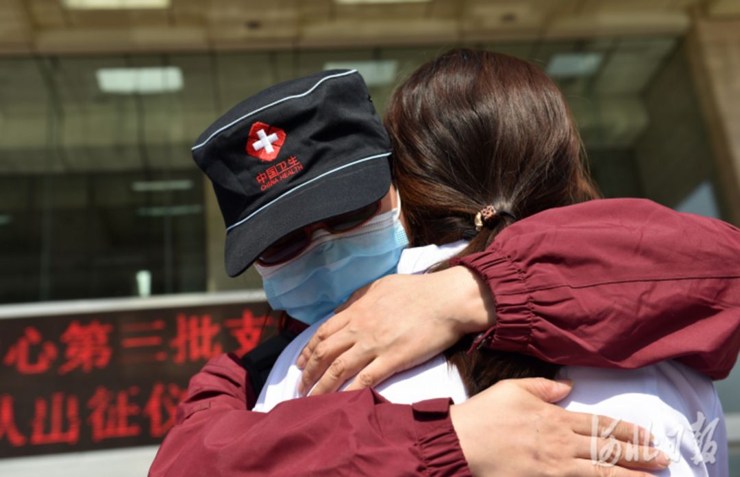 2月23日,队员高伟(左)与同事拥抱告别.