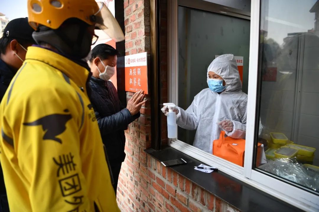 工作人员对外卖包装及外卖员双手进行消毒最后,打包好的菜品将被佩戴