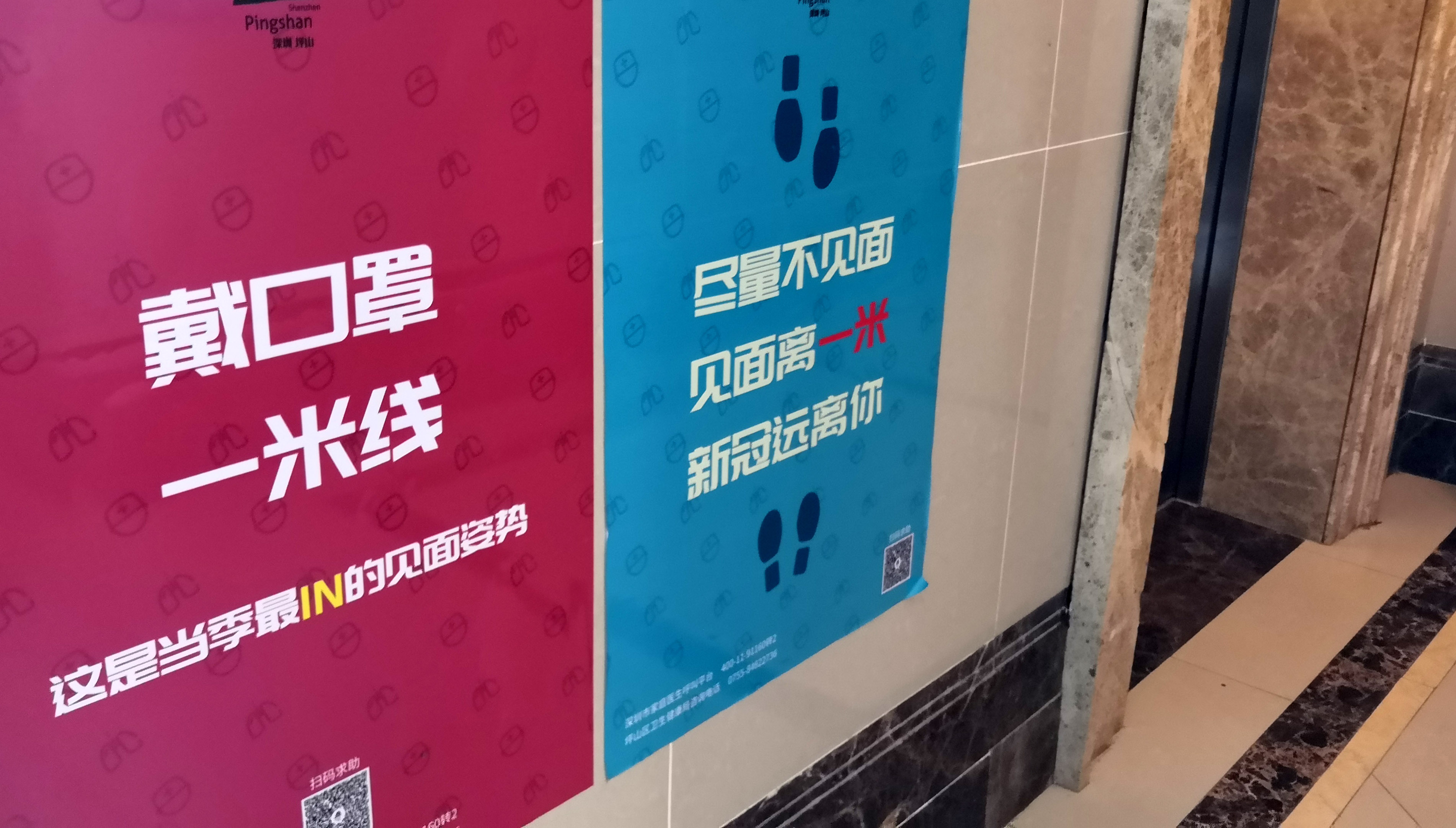 深圳坪山区金地朗悦小区电梯口旁张贴着疫情防控宣传海报(2月23日摄).