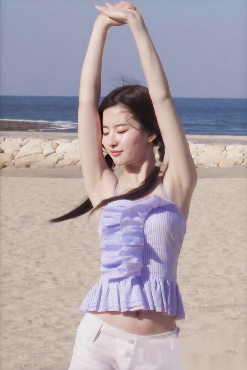 下身穿着一条比较短的白色热裤,刘亦菲的腰部被完全露着了外面,肚脐眼