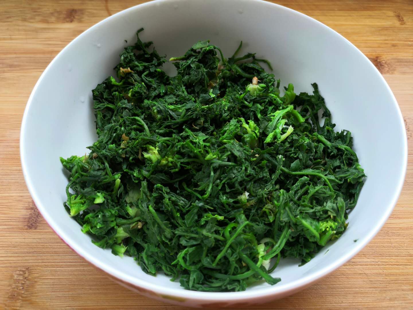 6,准备几个蒜粒切碎,1勺辣椒面,锅中热油浇到放入蒜末,辣椒面上拌匀.